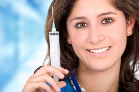 female doctor in a hospital smiling and holding a syringe on her hand