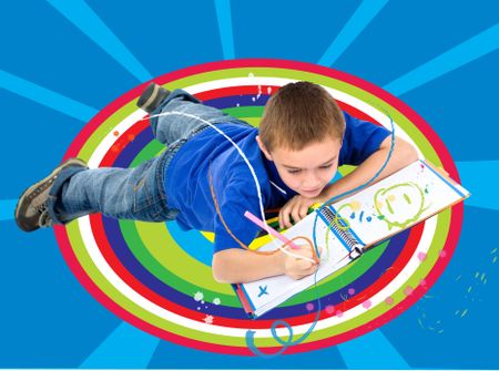 school boy coloring on the floor on a colorful background