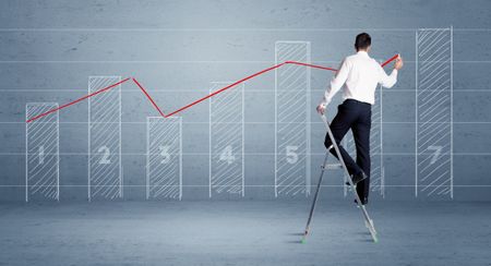 A man in elegant suit standing on a small ladder and drawing a chart on blue wall background with numbers, lines, blocks,