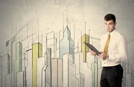 A young adult businessman standing in front of a wall with colorful drawings of buildings, charts, graphs, signs