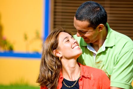 couple having fun and smiling at each other outdoors in their home