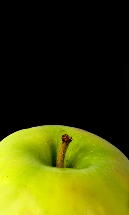 green apple close up over a black background