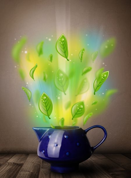 Tea pot with leaves and colorful abstract lights, close up