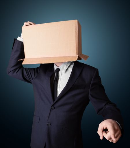 Businessman standing and gesturing with a cardboard box on his head