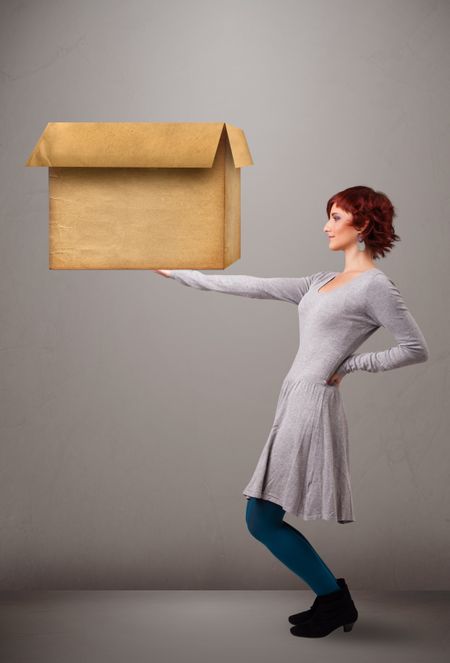 Beautiful young woman holding an empty cardboard box