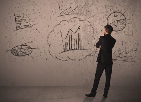 Businessman drawing a business project on a wall