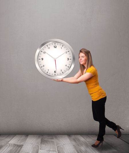 Attractive young lady holding a huge clock