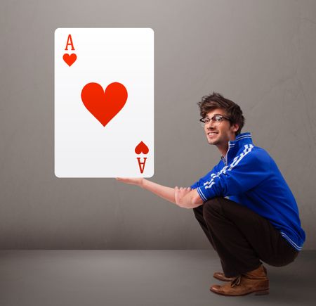 Attractive young man holding a red heart ace