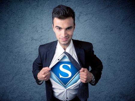 Businessman ripping off his shirt with superhero sign on his chest concept on background