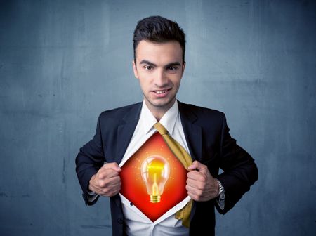 Businessman ripping off shirt and idea light bulb appears on his chest concept on backround