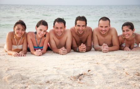 Group of friends lying on the sand at a beach