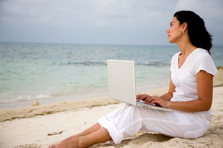 Woman working on a computer at the beach