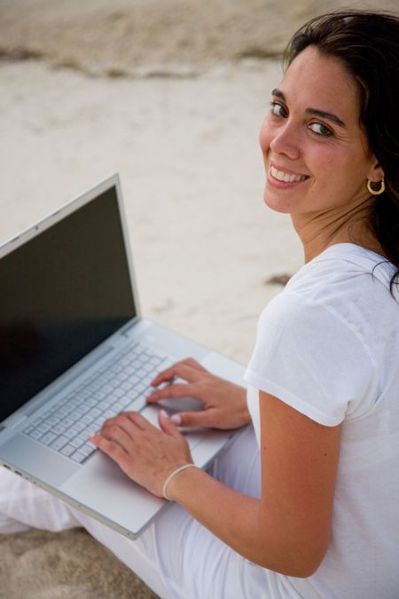 Woman outdoors working on a laptop computer
