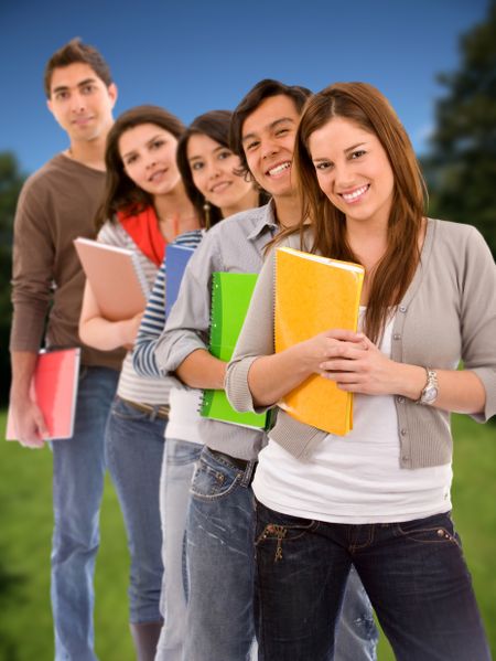 Group of students lined up holding notebooks outdoors