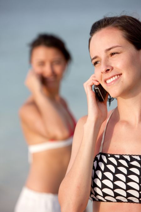 Beach women talking on the phone and smiling