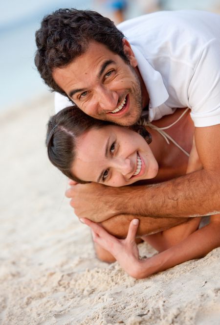 Loving couple lying at the beach on sand