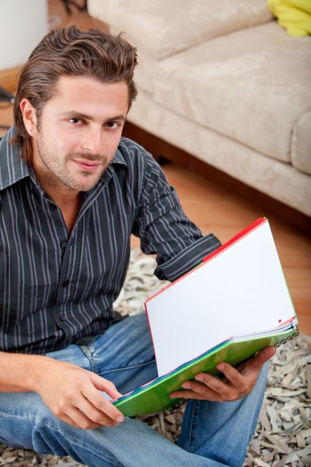 Handsome man studing with a notebook at home