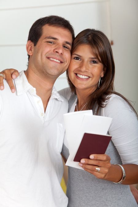 Happy travelling couple smiling and holding passports