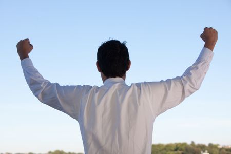 Successful business man with arms up outdoors