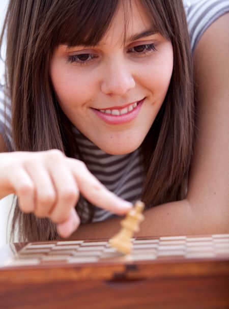 Portrait of a beautiful girl playing chess and smiling