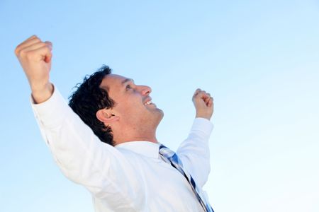 Successful business man with arms up smiling