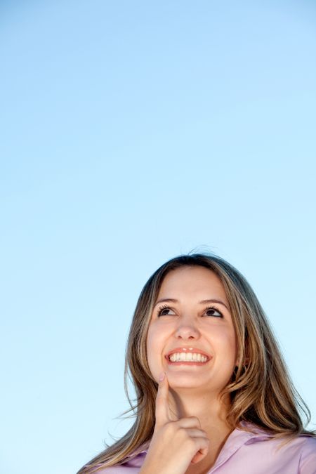 Smiley business woman thinking isolated over blue