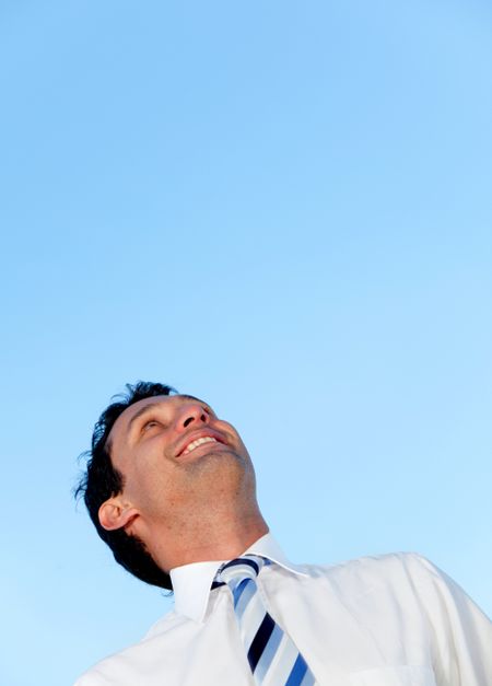 Happy business man looking at the sky