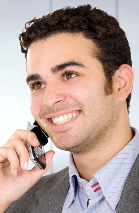 Business man on the phone smiling in an office environment
