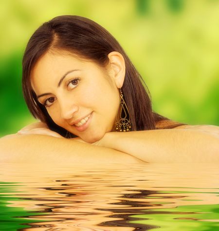 female summer portrait outdoors with water reflections in front of her