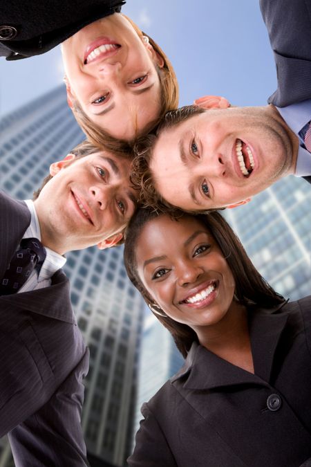 business-team-heads-together-corporate-buildings-36646498 Business team with heads together with corporate buildings behind