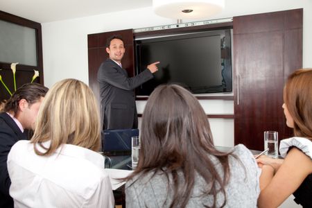 Business man in a presentation pointing in the screen