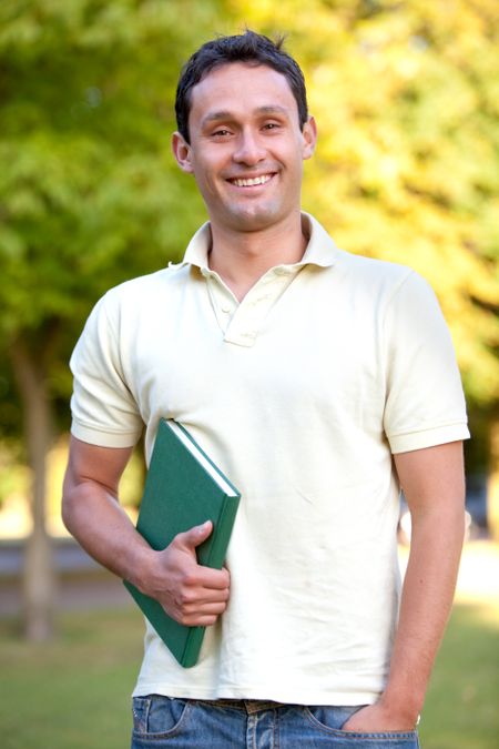 Casual male student outdoors with a notebook