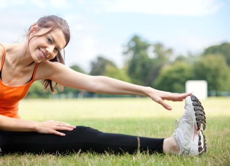 Athletic woman stretching her leg at the park