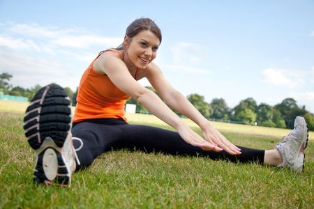 Beautiful slim woman stretching at the park