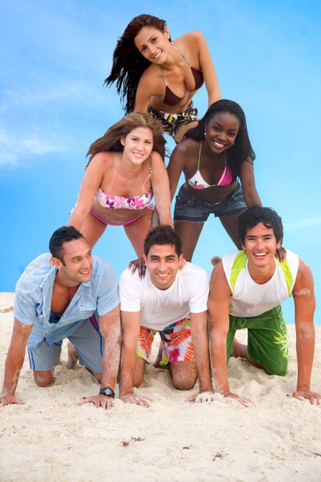 Group of people making a human pyramid at the beach