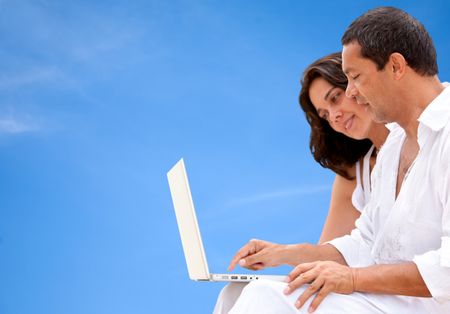 couple working on a laptop outdoors