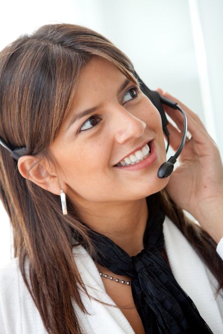 Business woman in an office smiling with a headset