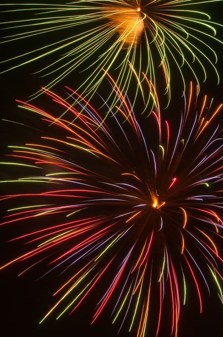 Two large multicolored bursts of fireworks