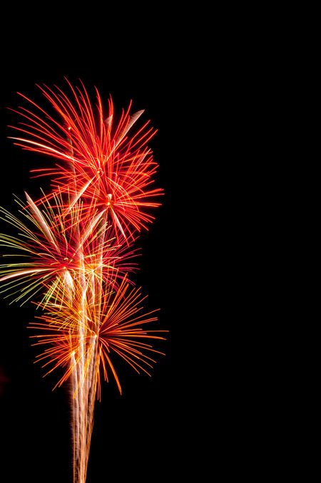 Intense reddish orange bursts of fireworks close together