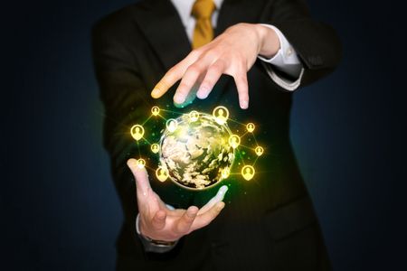 Businessman holding a shining globe with social media connection
