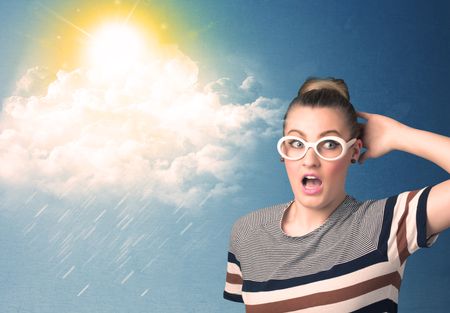 Young person looking with sunglasses at clouds and sun concept on blue background