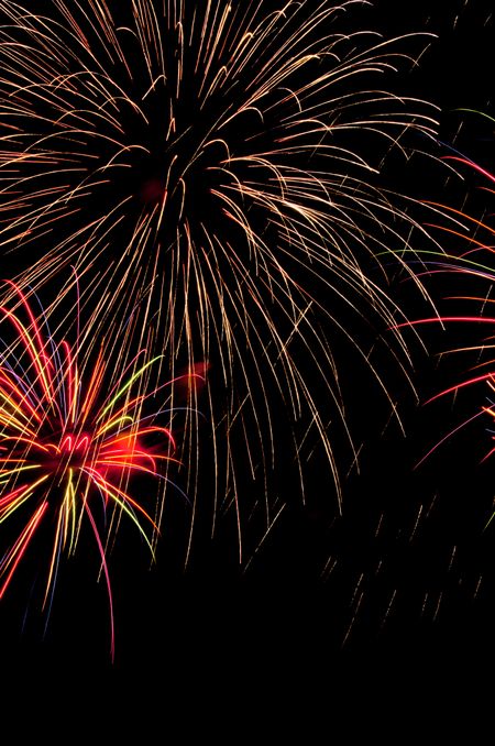 Huge "falling-ember" burst of fireworks above smaller, multicolored burst