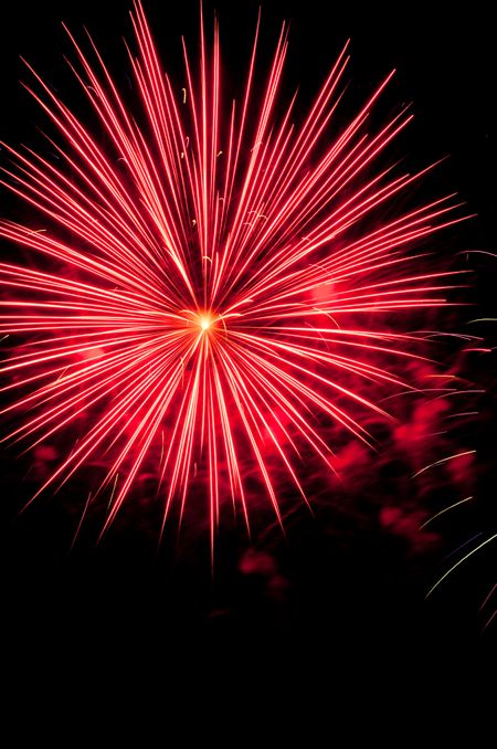 Pow! Pinkish white burst of fireworks with reddish smoke