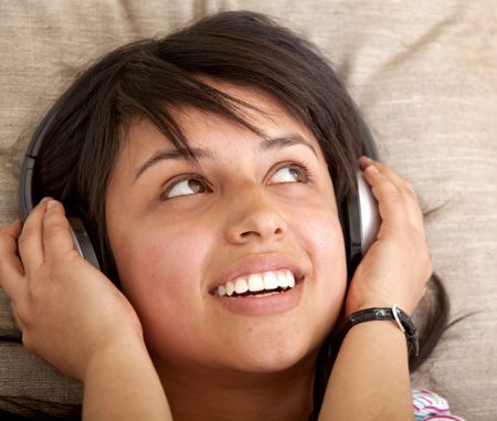 Girl lying her head on a cushion with earphones