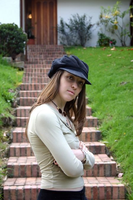 confident female in front of a countryside house