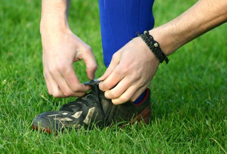 footballer tying his boots laces