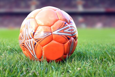 orange soccer ball in a football stadium