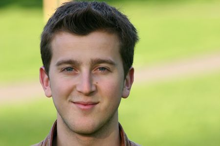 casual guy smiling in a park