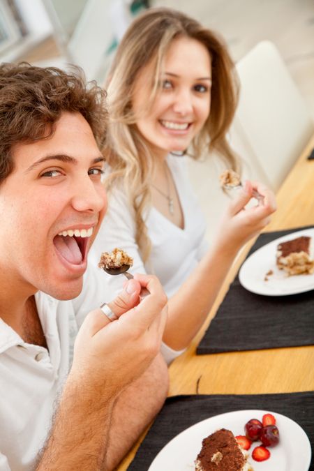 BEautiful happy couple eating tiramisu for dessert