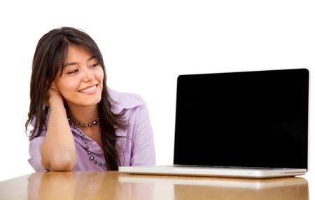 Business woman staring at a laptop isolated over white